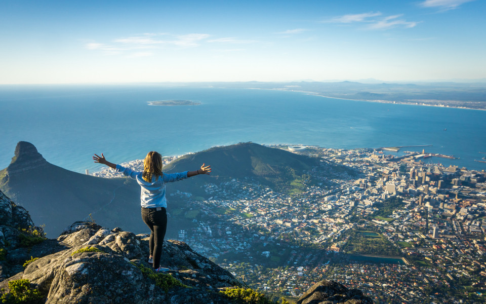 Frau auf einem Berg in S&uuml;dafrika mit Meerblick und Stadtblick
