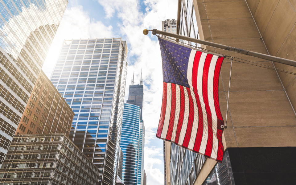 USA-Flagge in Chicago mit Wolkenkratzern im Hintergrund
