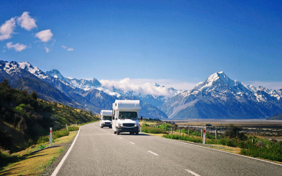 Zwei wei&szlig;e Wohnwagen unterwegs in Neuseeland. 