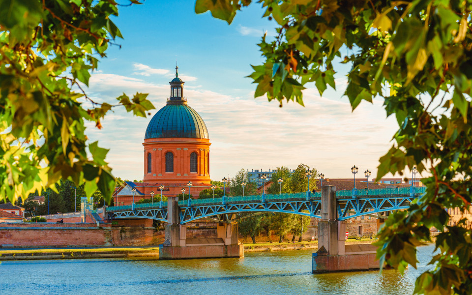 Landschaft bei Sonnenuntergang entlang der Garonne und der Kuppel von La Grave in Toulouse, Frankreich