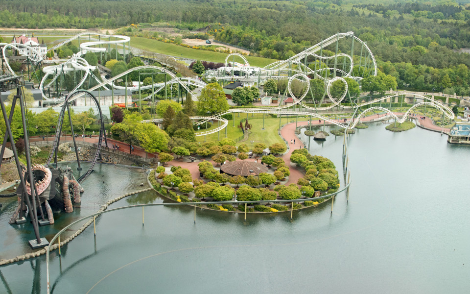 Achterbahn im Heide Park Soltau mit steilen Abfahrten, mehreren Loopings und einer kurvigen Strecke, umgeben von grünen Landschaften.