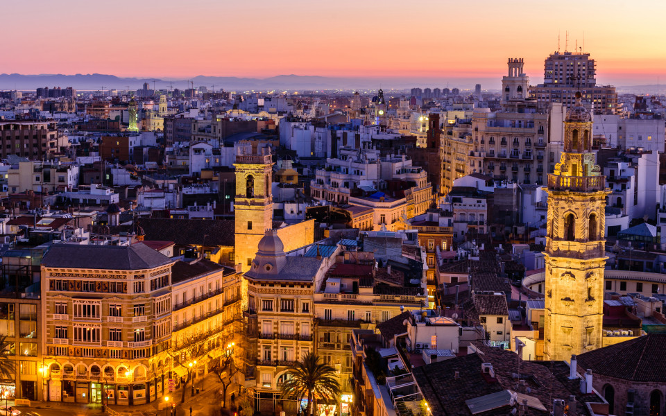Luftaufnahme von Valencia bei Sonnenuntergang mit beleuchteter Plaza de la Reina.